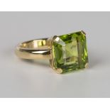 An 18ct gold ring, claw set with a cut cornered square step cut peridot, weight 8.4g, ring size