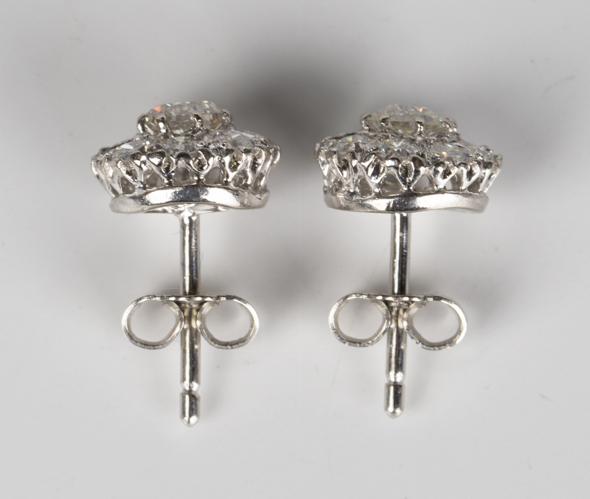 A pair of diamond cluster earrings, each claw set with the principal circular cut diamond within a - Image 2 of 4