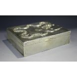A Chinese silver cigar box, the hinged lid decorated in relief with a dragon on a stippled ground,