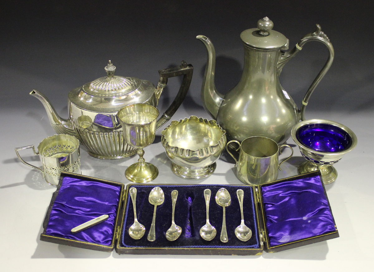 A collection of plated items, including a pair of candlesticks, two teapots and a tankard.Buyer’s