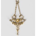 A gold and seed pearl pendant necklace in an openwork design with a floral and foliate spray