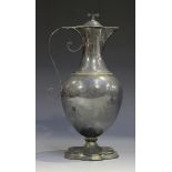 A late Victorian silver ewer decanter, the ovoid body flanked by a scroll handle, raised on a