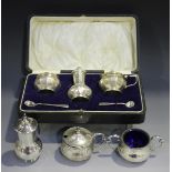 A George V silver three-piece condiment set of faceted baluster form, comprising salt, pepper caster