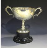 A George V silver footed cup, the circular bowl flanked by two angular handles, raised on a tapering
