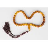 A single row komboloi/worry beads string of thirty-three uniform oval vari-coloured mottled