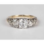 A gold and diamond five stone ring, mounted with a row of cushion cut diamonds graduating in size to