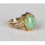 A gold, jade and diamond ring, claw set with the oval cabochon jade between diamond two stone