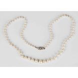 A single row necklace of graduated cultured pearls on a white gold, platinum and diamond set oval