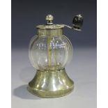 A late Victorian silver mounted cut glass pepper mill of globular faceted form with a flared base,