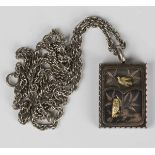 A late Victorian Aesthetic movement silver pendant locket of hinged rectangular form, the front