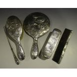 An early 20th century Chinese silver mounted five-piece dressing table set, each piece embossed with