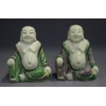 A pair of Chinese famille verte enamelled biscuit porcelain figures of Buddha, Kangxi period, each