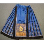 A Chinese blue silk pleated apron skirt, late Qing dynasty, the front and back finely worked in gilt