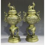 A pair of Japanese bronze vases and covers, Meiji period, each globular body cast with panels of