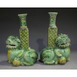 A pair of Chinese famille verte enamelled biscuit porcelain Buddhistic lion spill vases, Kangxi