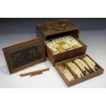 A Chinese Mahjong set, early 20th century, with bone and bamboo tiles, contained within a brass