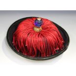 A Chinese mandarin's purple silk hat, late Qing dynasty, with black velvet trim, red tassels and