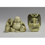 A Japanese carved ivory netsuke, Meiji period, modelled as Hotei seated beside a boy and