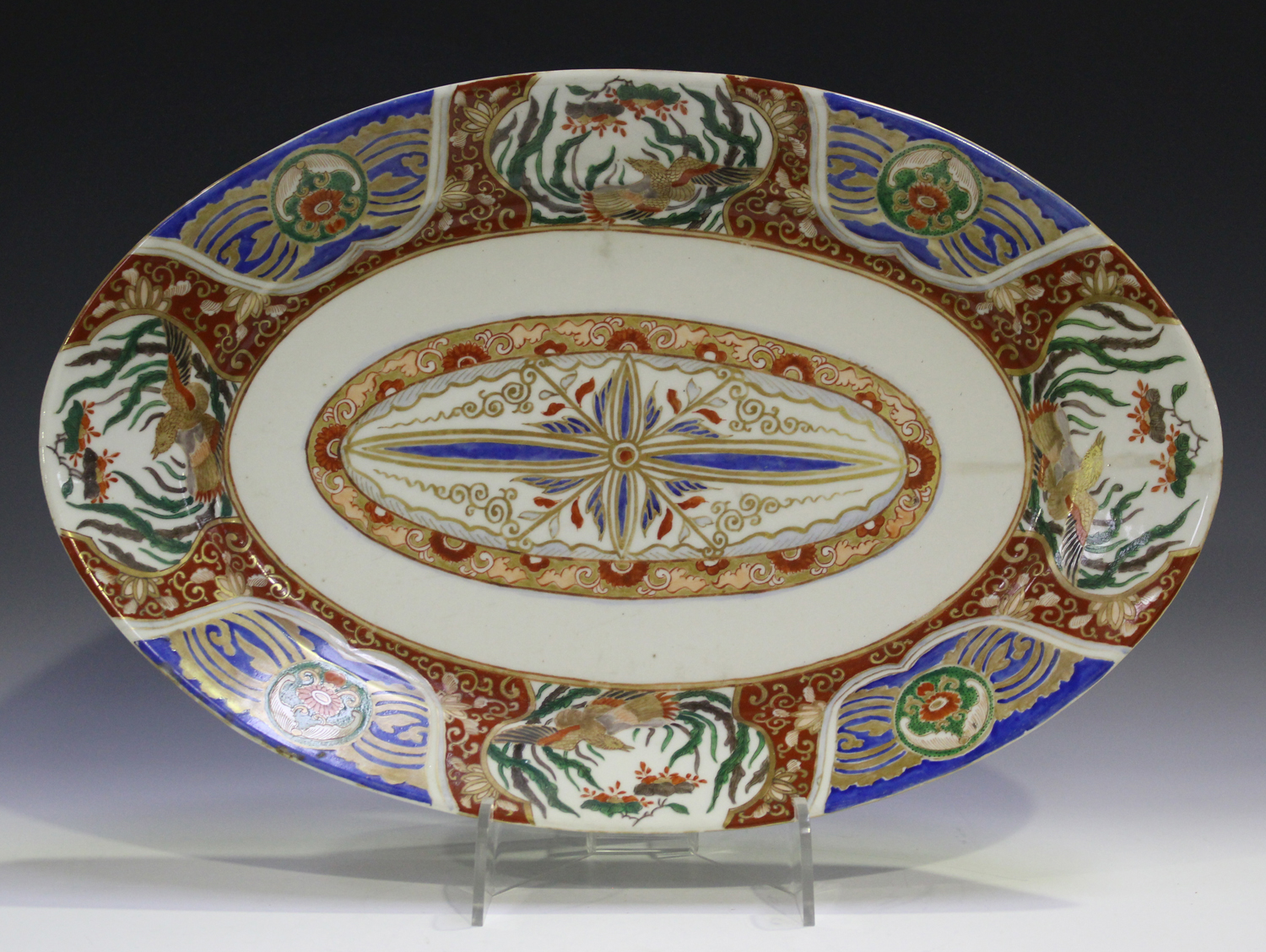 A Japanese Imari porcelain oval dish, Meiji period, painted and gilt with a central foliate