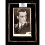 AUTOGRAPH. A black and white postcard signed by Basil Rathbone, 14cm x 9cm, within a later frame.