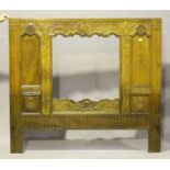 A 19th century French walnut headboard, the central aperture within a frame of carved foliage,