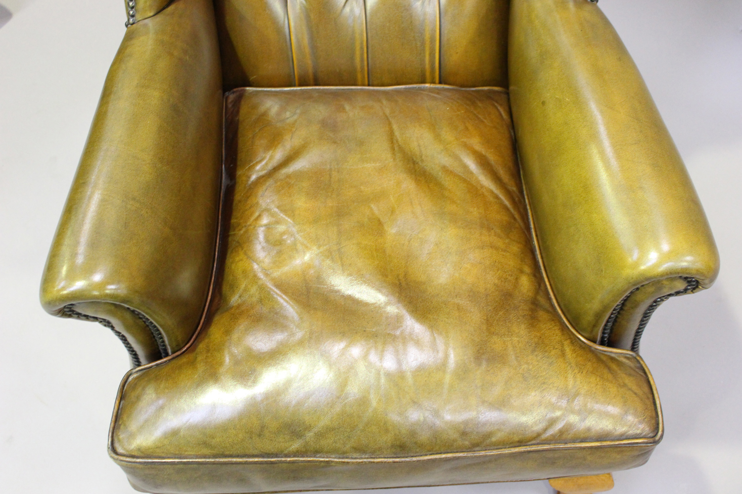 A 20th century George III style wing back armchair, upholstered in buttoned khaki leather, on - Image 2 of 3