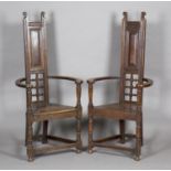 A near pair of early 20th century Arts and Crafts stained oak 'Shakespeare' armchairs, in the manner