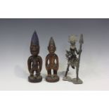 Two Yoruba Ere Ibeji carved wooden figures, both modelled as standing males, one with applied bead
