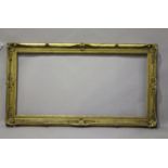 A late 19th century giltwood and gesso picture frame with foliate scroll crestings, aperture size