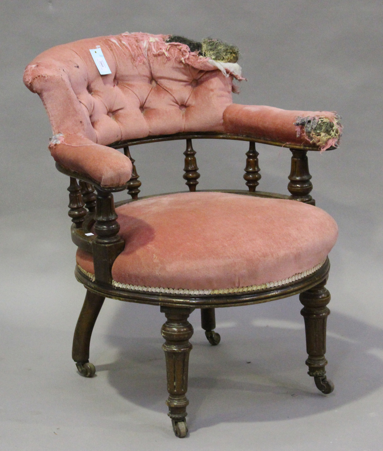 A late Victorian walnut framed tub back nursing chair, on fluted legs and castors, height 77cm,