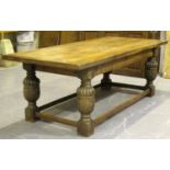 A 20th century Jacobean Revival oak refectory table, the thick plank top raised on finely carved