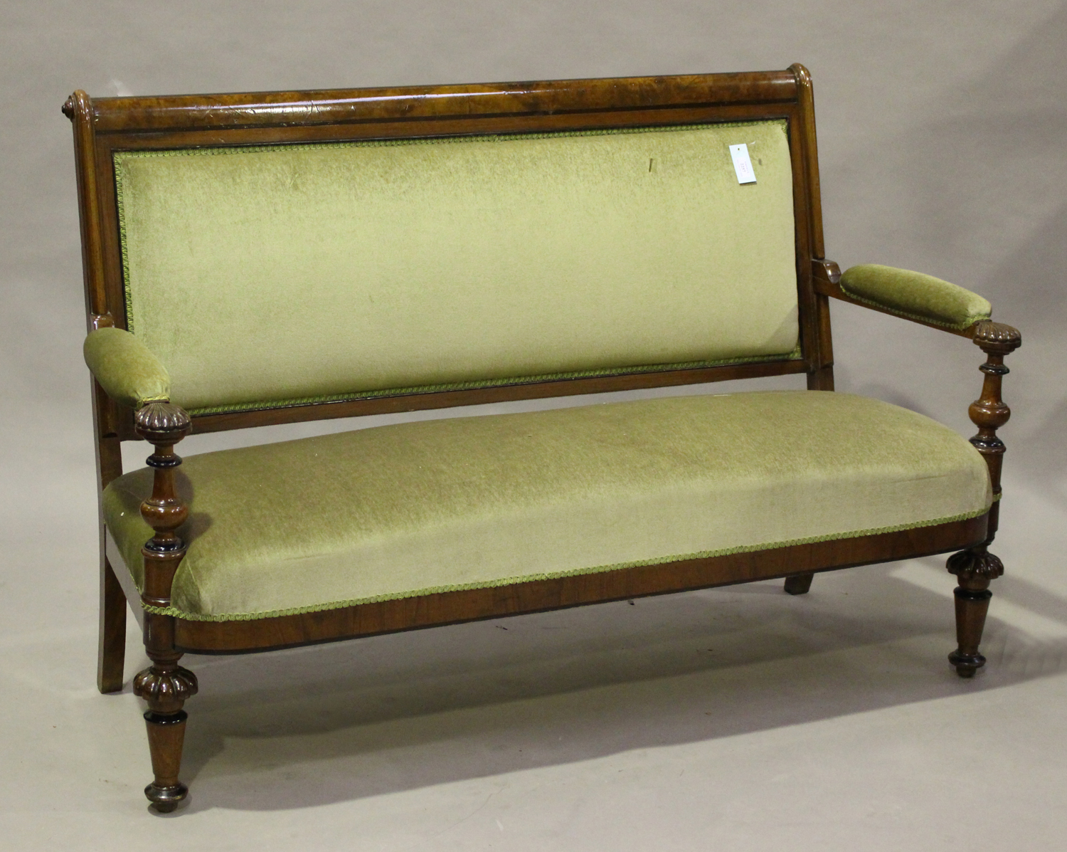 A late Victorian burr walnut showframe settee with ebonized banding, the handrests carved with