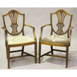 A pair of early 20th century Sheraton style mahogany elbow chairs with drop-in needlework seats,