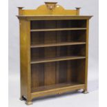 An Edwardian Arts and Crafts oak open bookcase with a carved foliate gallery back and four