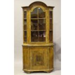 An 18th century Continental walnut floor-standing corner cabinet with an arched cavetto moulded