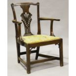 A George III mahogany pierced and carved splat back elbow chair with a needlework drop-in seat,