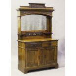 An Edwardian Arts and Crafts oak mirror back sideboard, carved with panels of stylized foliage and