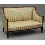 An Edwardian mahogany and boxwood inlaid salon settee, upholstered in striped damask, height 83cm,