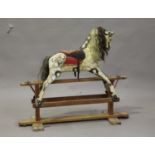 An early 20th century carved wooden rocking horse, raised on a wooden stand, height 90cm, length