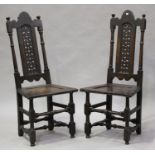 A pair of late 17th century oak backstools with pierced fretwork back panels above recessed panel