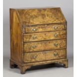 A George I walnut bureau with feather banded borders, the fall-flap enclosing a fitted interior,