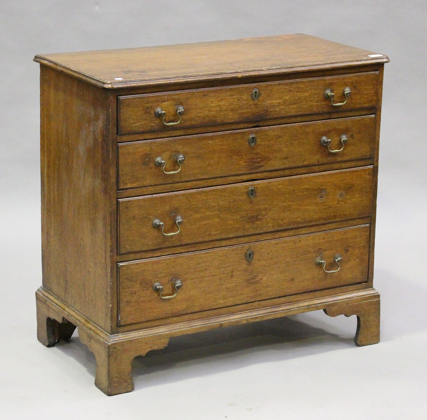 A George III oak chest of four graduated long drawers, on bracket feet, height 85cm, width 88cm,