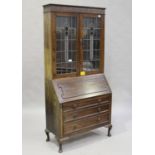 A George V oak bureau bookcase, the top fitted with stained and leaded glass doors, height 200cm,