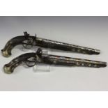 A near pair of late 19th century Eastern flintlock pistols, both with overall nickel mounts and