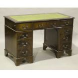 A late 20th century reproduction mahogany twin-pedestal desk, the green leather inset top above