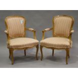 A pair of 20th century Louis XV style beech showframe fauteuil armchairs, upholstered in striped