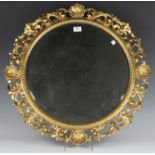 A late 19th/early 20th century Florentine giltwood circular wall mirror, the bevelled plate within a