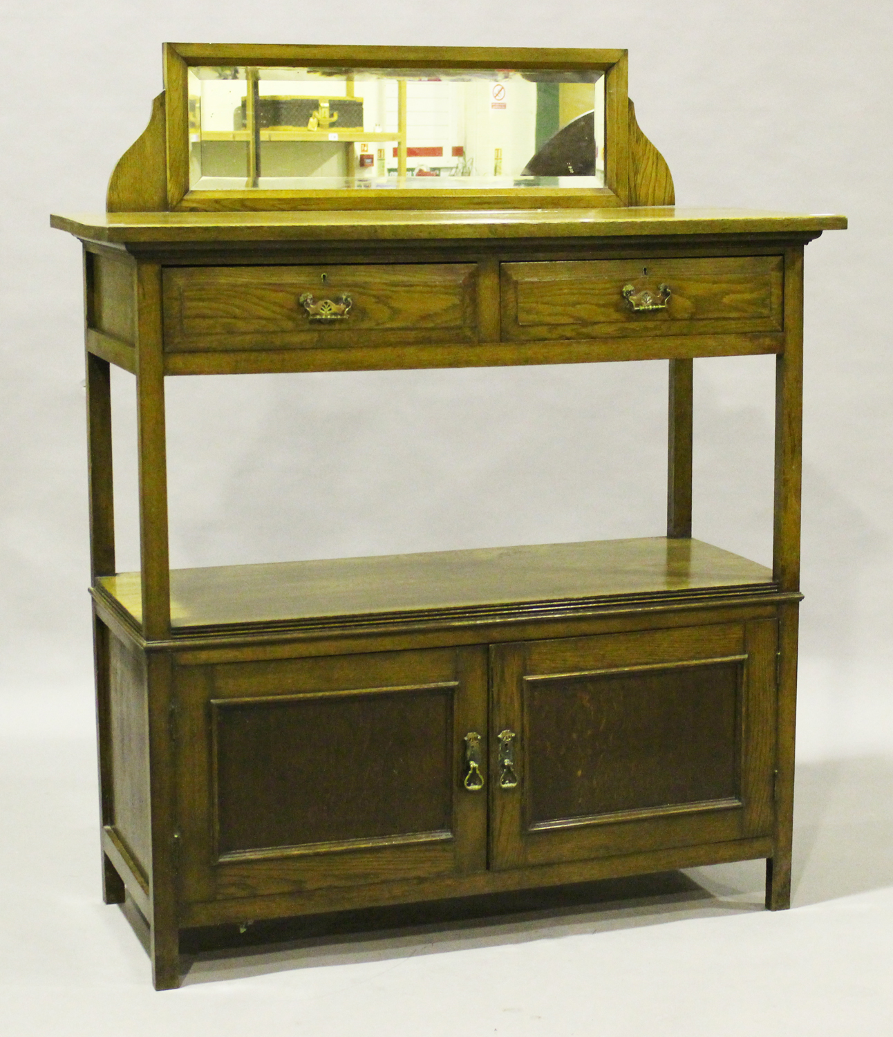 An Edwardian oak two-tier buffet, the mirror back above two drawers and two doors, height 150cm,