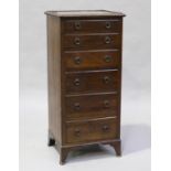 An Edwardian mahogany narrow chest, carved with a flowerhead and ribbon band, on bracket feet,