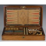 A late Victorian mahogany cased games compendium, the hinged lid enclosing a boxwood and ebony